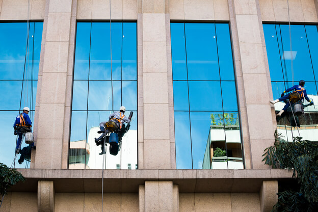 Group of men cleaning windows on a high rise building. This is a part of our commercial window cleaning services